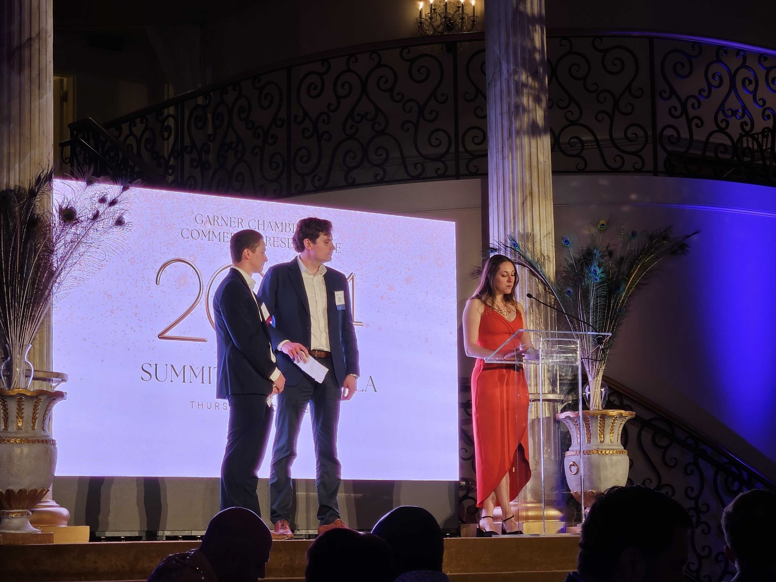 Three team members presenting an award on stage at the 2024 Garner Chamber of Commerce Summit Awards Gala.